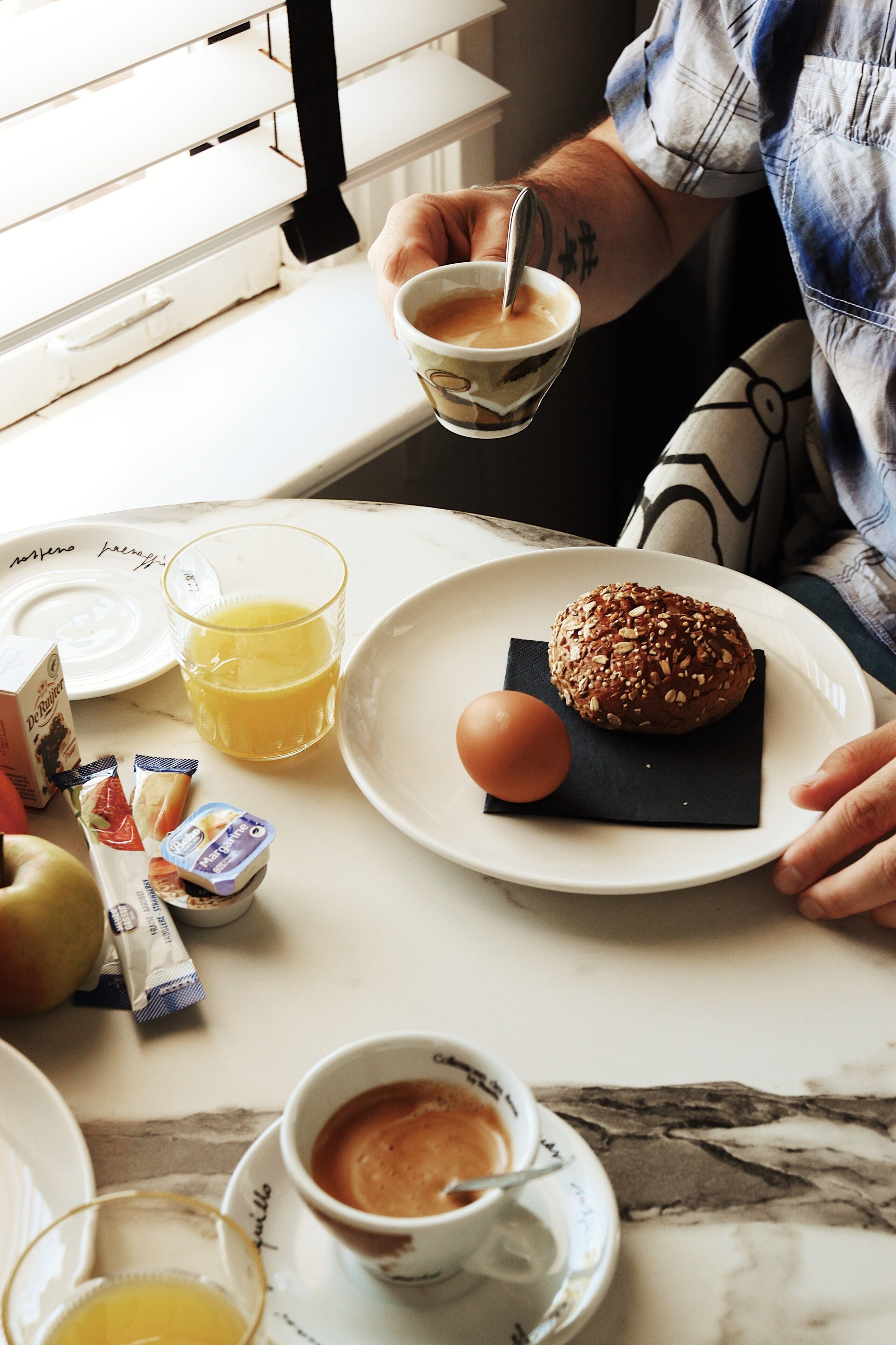 A breakfast setting with a plate of food, a glass of orange juice, and a cup of coffee.