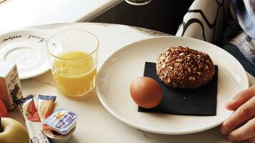 A breakfast setting with a plate of food, a glass of orange juice, and a cup of coffee.
