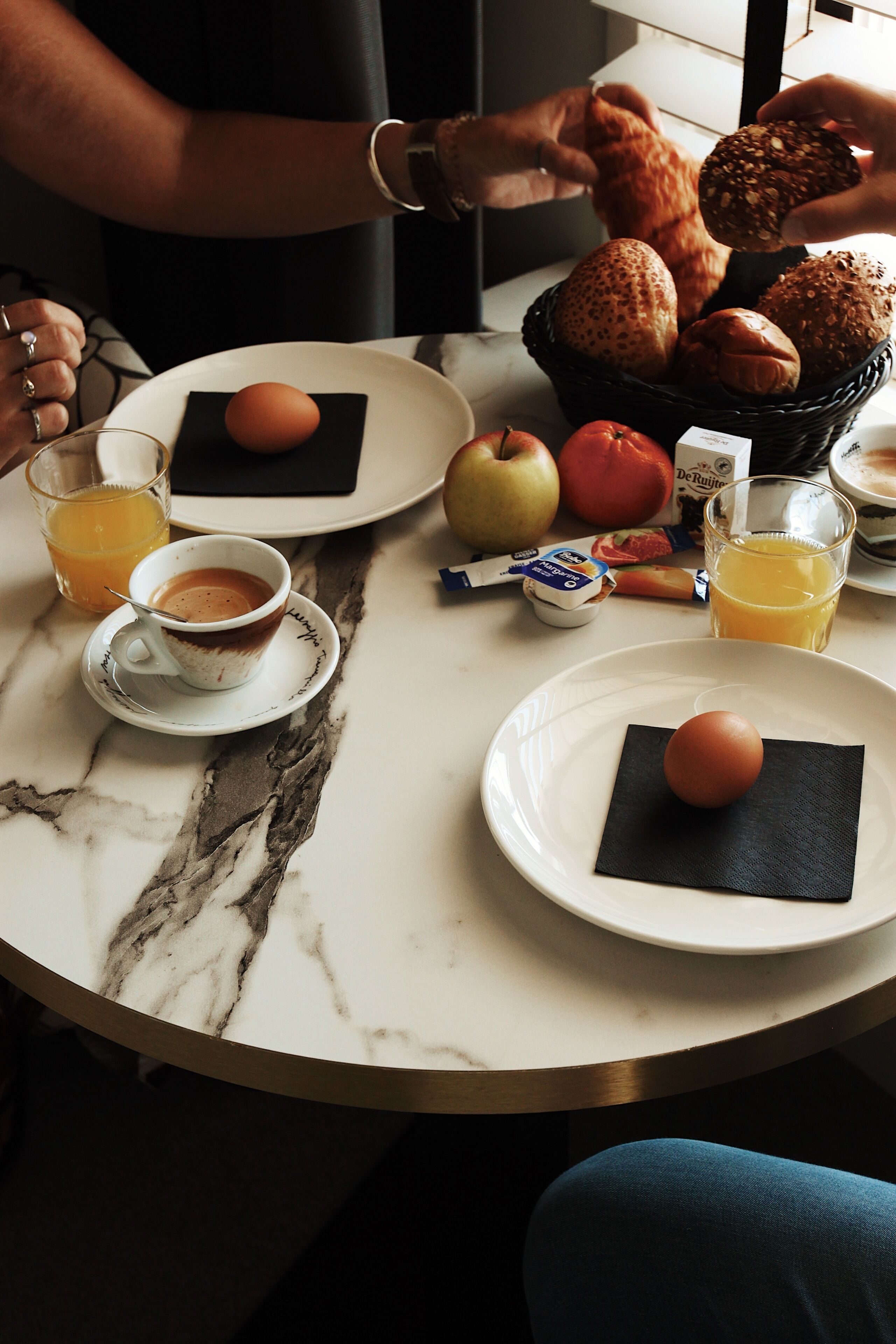 Desayuno con platos de huevos, pan y jugo.