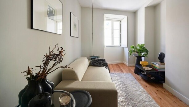 A modern living room with a sofa, a coffee table, a floor lamp, and a bookshelf.