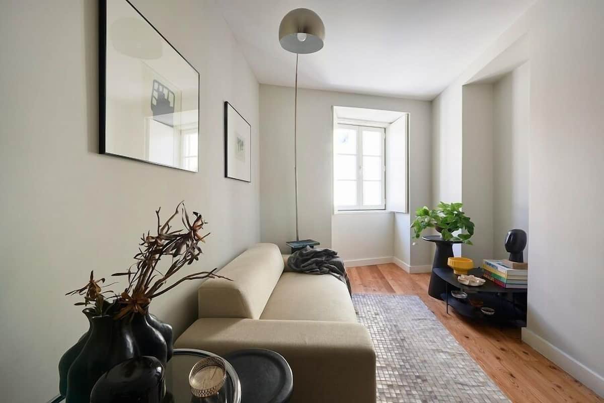 A modern living room with a sofa, a coffee table, a floor lamp, and a bookshelf.