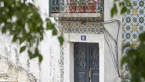 Un immeuble doté d’un balcon, d’une porte avec un numéro et d’un escalier.