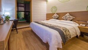 A hotel room with a bed, bedside table, lamp, chair, and a desk. - GreenTree Inn Nantong Chongchuan District Middle Changjiang Road Express Hotel (Nantong)