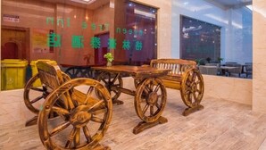 A wooden table with large wheels, a bench, and a window with green text. - GreenTree Inn Nantong Chongchuan District Middle Changjiang Road Express Hotel (Nantong)