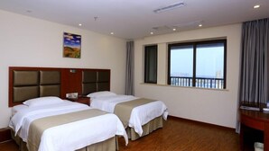 A hotel room with two beds, a wooden floor, a large window with a view, and a painting on the wall. - GreenTree Inn HeFei Heyu Road Dayun City Express Hotel (Hefei)