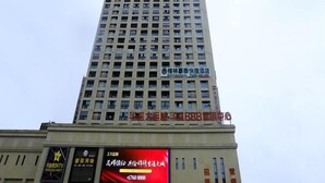 A tall building with multiple floors, featuring a prominent sign for a hotel and a large digital billboard advertising a local business. - GreenTree Inn HeFei Heyu Road Dayun City Express Hotel (Hefei)