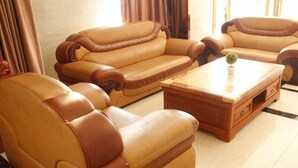 A living room with a sofa set and a coffee table. - Greentree Inn Shantou Dahao (Yingtan)