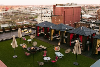 A modern lounge area with a fireplace, leather sofas, and a patterned carpet. at The Nash