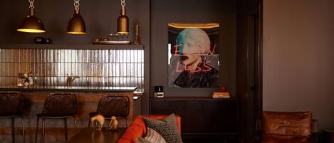 Una sala de estar moderna con un sofá rojo, una mesa de centro y una zona de bar con taburetes.