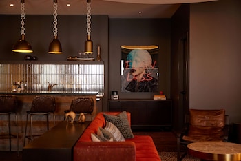 Relax in this inviting living space with a central dining island, comfortable sofa, and stylish artwork. at Bobby Hotel