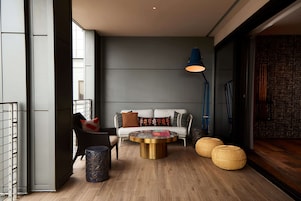 Uma sala de estar moderna com um sofá, mesa de centro e abajur.