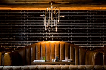 Enjoy a cozy dining experience in our intimate restaurant with a unique chandelier and comfortable booth seating. at Bobby Hotel