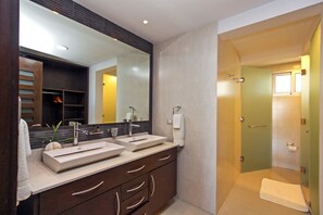 Une salle de bain moderne avec un meuble-lavabo à deux vasques, un grand miroir et une douche à l’italienne.
