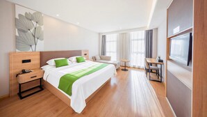 A modern hotel room with a large bed, bedside tables, a desk, and a TV. - GreenTree Inn Tianjin Xiqing Development Zone Renrenle Square Express Hotel (Tianjin)
