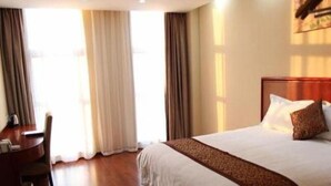 Quarto de hotel com uma cama grande, uma mesa e uma cadeira.