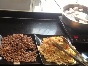 A kitchen counter with a plate of beans and a plate of shredded vegetables.