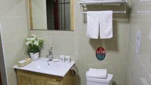 A bathroom with a sink, mirror, toilet, and towel rack. - GreenTree Inn Tianjin Xiqing Development Zone Renrenle Square Express Hotel (Tianjin)