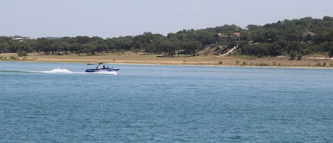 Un bote sobre aguas tranquilas, con un paisaje montañoso al fondo.