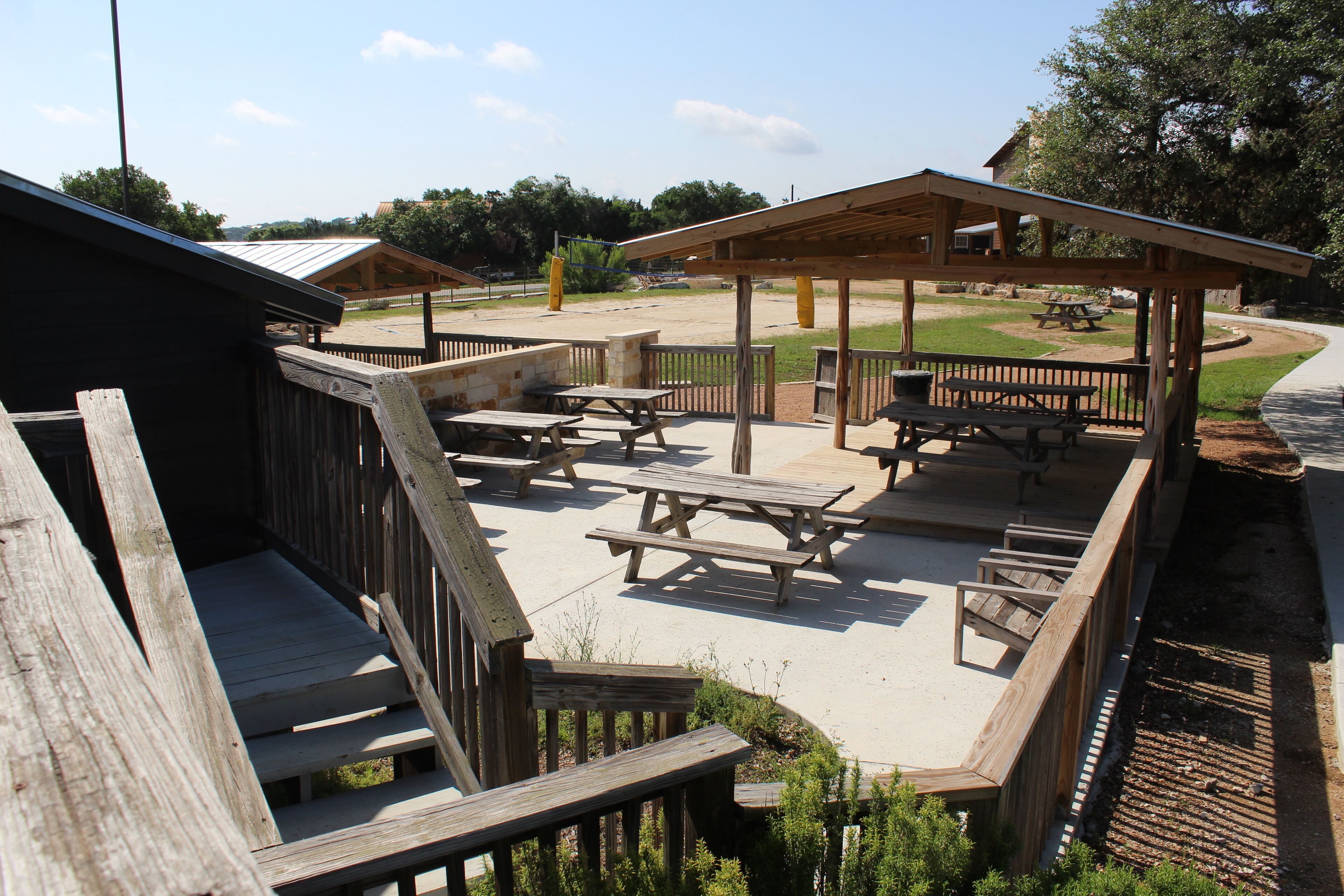 A wooden deck with picnic tables and a covered pavilion.