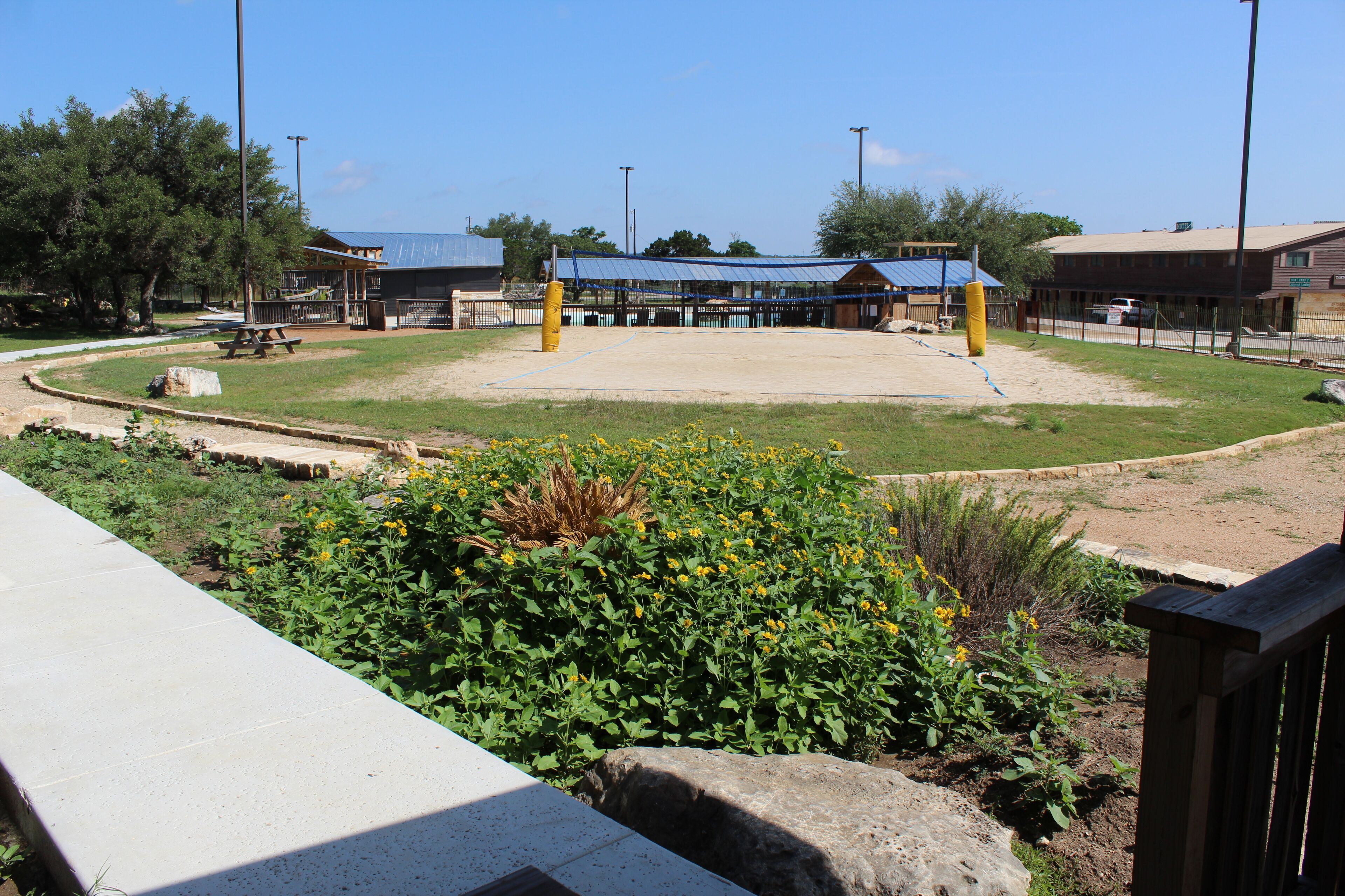 A baseball field with a pavilion, a picnic table, and a wooden fence.