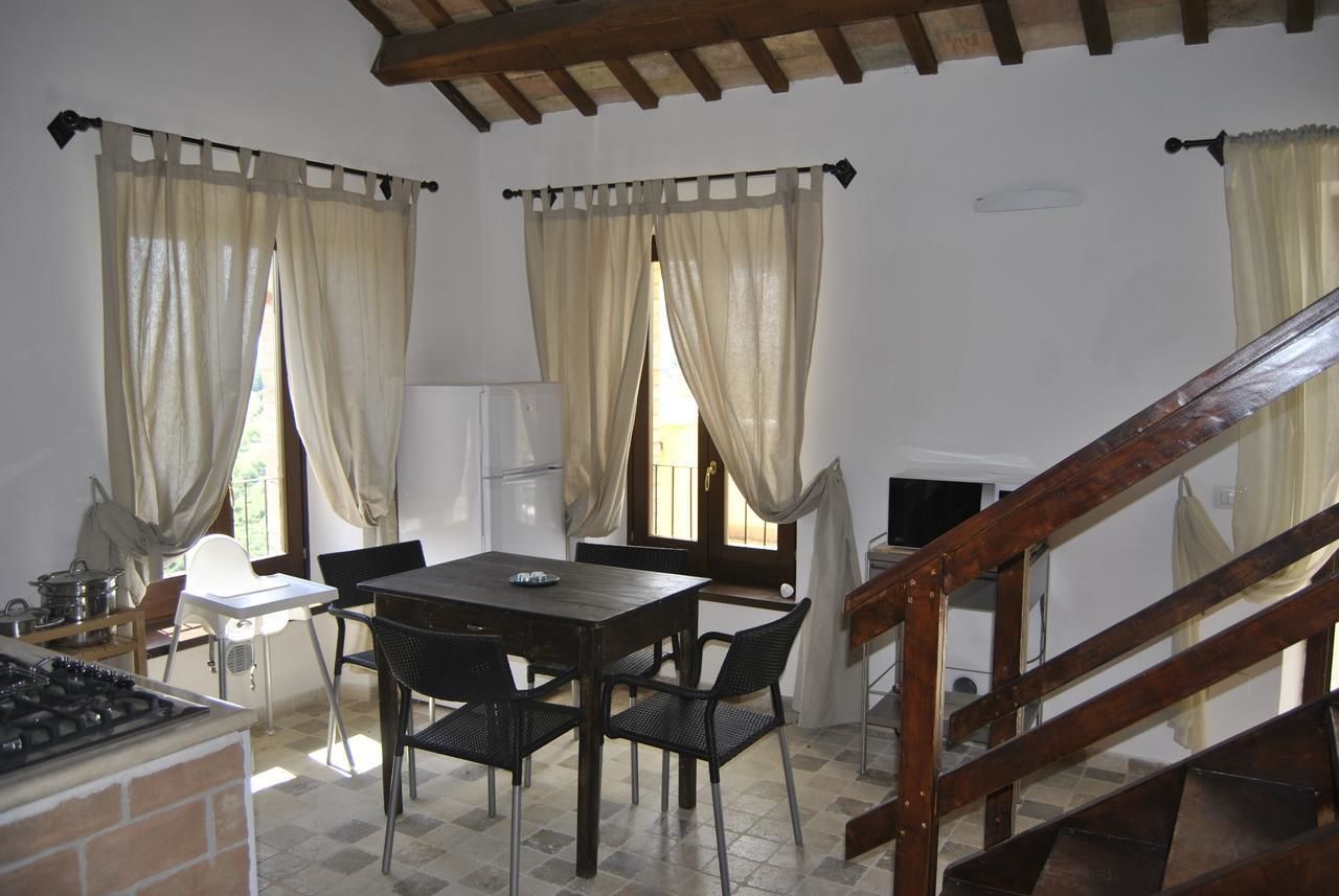 A kitchen with a stove, a table with chairs, and a staircase.