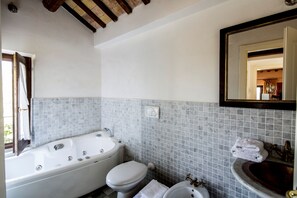 Un baño con bañera, inodoro y lavamanos.