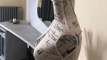 Ein Zimmer mit einem modernen Schreibtisch, einem großen Spiegel und einer dekorativen Vase mit handgeschriebenen Notizen.