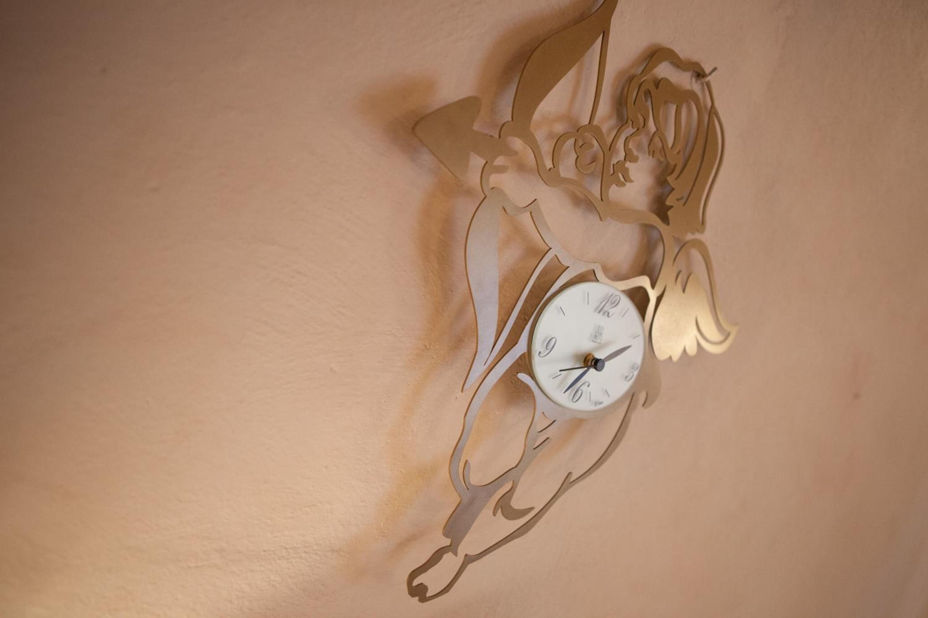Eine Wanduhr mit einem besonderen Design, das einen Engel darstellt.
