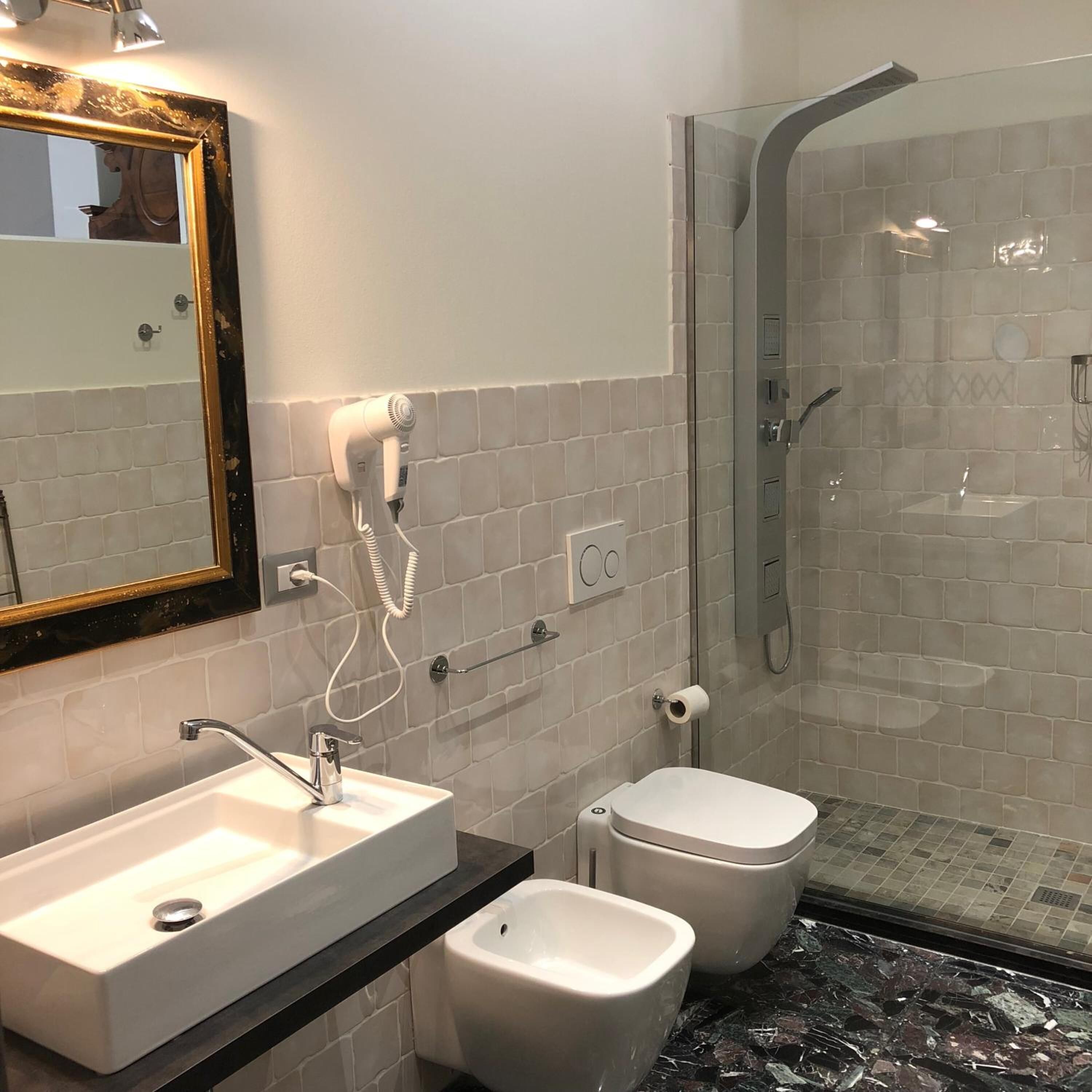 Un baño moderno con lavamanos, bidé y ducha con mampara de vidrio.
