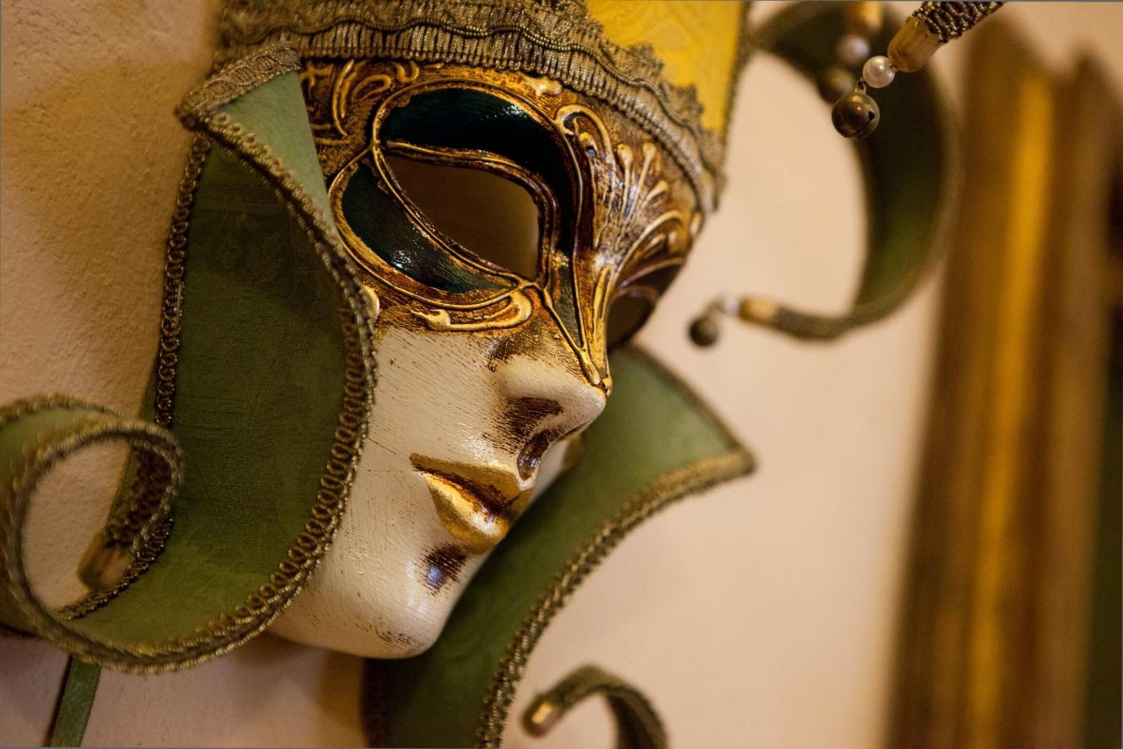 A close-up of a decorative mask with intricate designs and a chain detail.