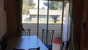 Un comedor con una mesa y sillas, un patio con puerta corrediza de vidrio y un ventilador de techo.