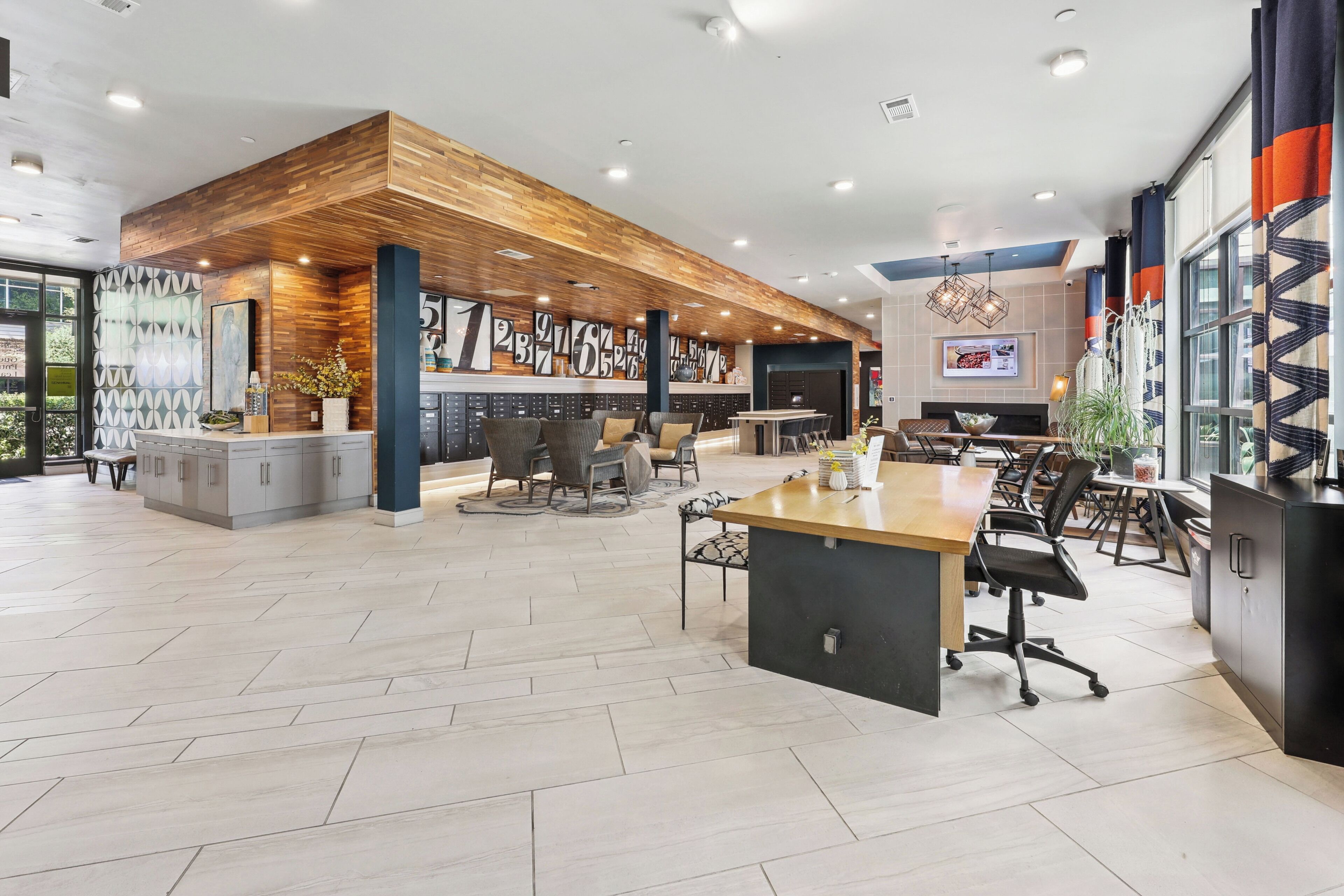 Cocina amplia y moderna con una pared de acento de madera, una isla central y un comedor con sillas y una mesa.