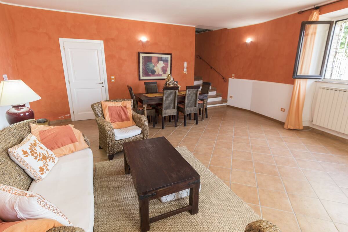 Una sala de estar con sofá, mesa de centro y mesa de comedor.