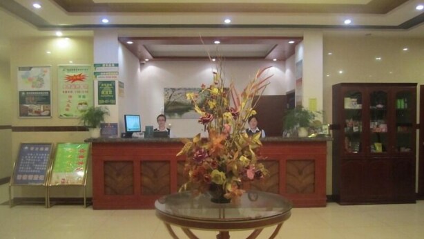 A reception area with a glass-top table, a reception desk, and a cabinet with glass doors. - GreenTree Inn Nantong Tongzhou Bus Station Express Hotel (Nantong)