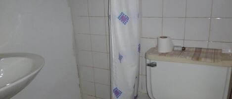 A small bathroom with a toilet, a sink, and a shower curtain.