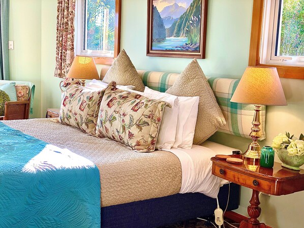 A neatly arranged bedroom with a bed, pillows, a bedside table with a lamp, and a painting on the wall. - Ah House Nelson City B&B (Nelson)