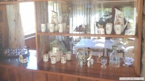 Une vitrine en bois contenant divers objets en céramique.