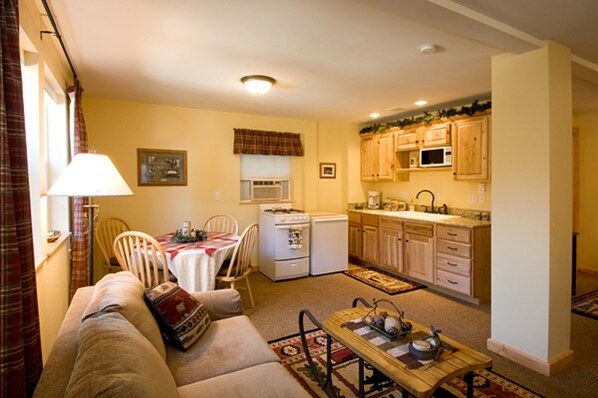 A compact living space with a kitchenette, a dining area, and a seating area with a sofa and table. - Haus Hanika - Adults Only (Leavenworth)