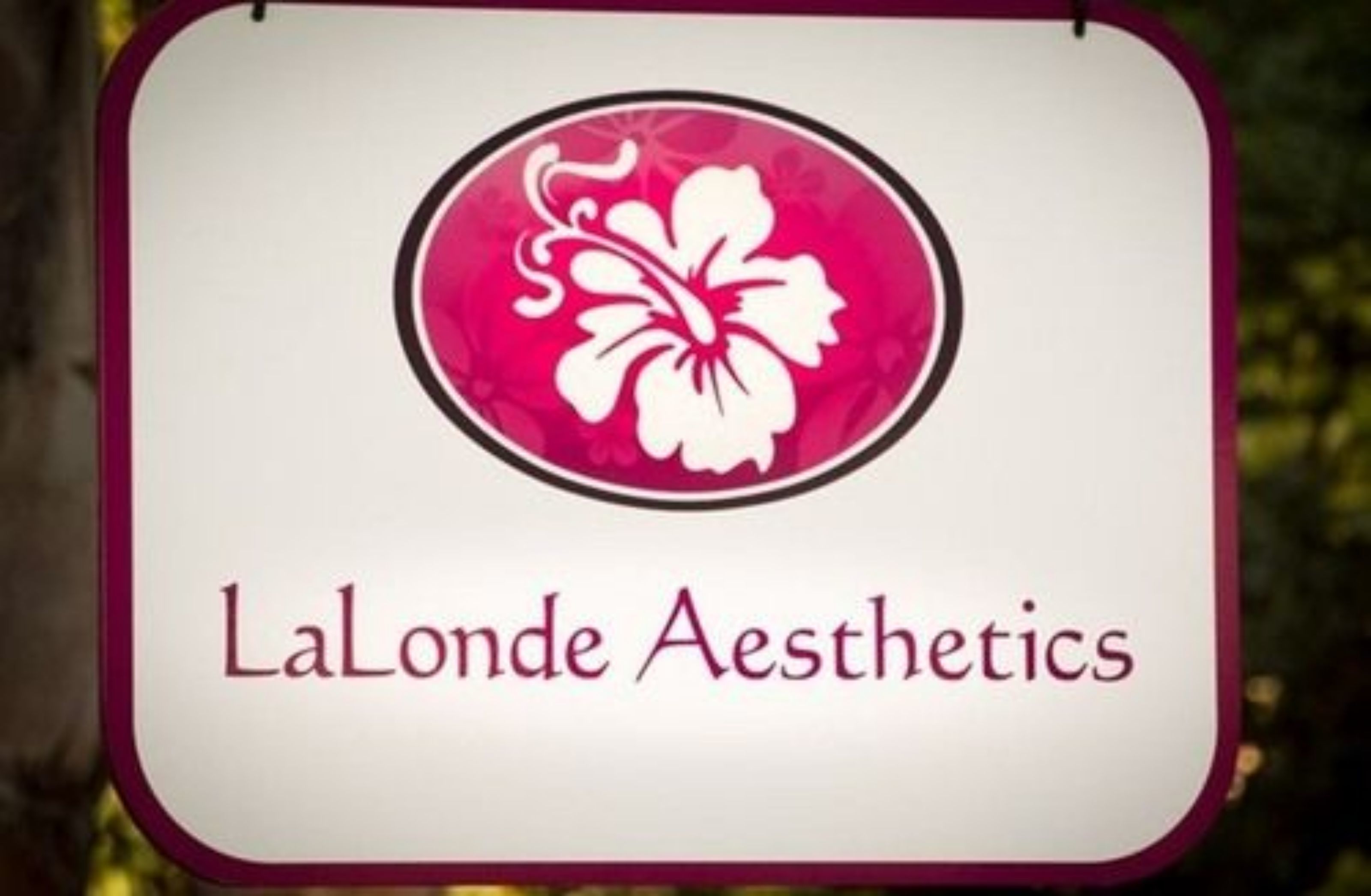 A sign with a hibiscus flower and the text "LaLonde Aesthetics".