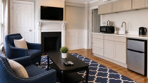 A modern living room with a fireplace, a flat-screen TV, a sofa, and a coffee table. - Bellevue House (Newport)