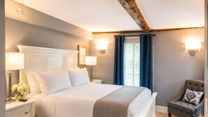 A bedroom with a bed, bedside tables, a chair, and a window with curtains. - Bellevue House (Newport)