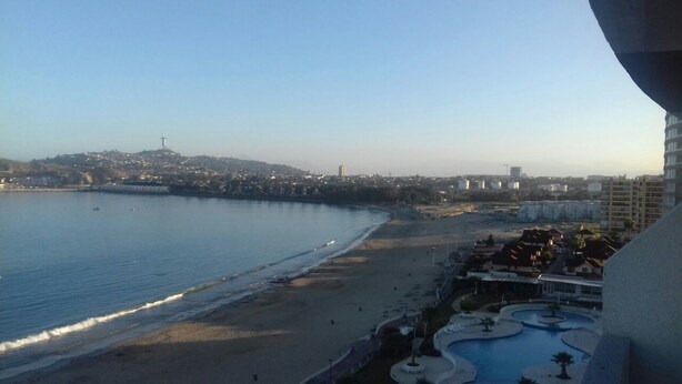 A coastal view with a beach, a swimming pool, and a cityscape in the background. - Depto La Herradura Coquimbo 974 (Coquimbo)