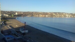 A coastal view with a beach, a clear sky, and buildings in the background. - Depto La Herradura Coquimbo 974 (Coquimbo)