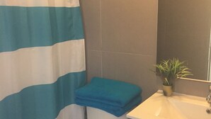 A bathroom with a toilet, a sink, and a shower curtain. - Depto Laguna del Mar La Serena 975 (La Serena)