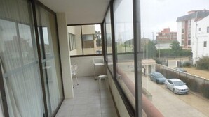 A balcony with a view of parked cars and buildings. - Depto Centro Algarrobo 1029 (Algarrobo)