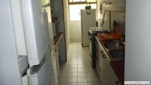 A compact kitchen with white cabinets, a refrigerator, a sink, and a window providing natural light. - Depto Centro Algarrobo 1029 (Algarrobo)