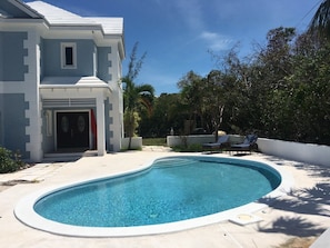 A modern house with a swimming pool, a covered patio, and a view of the surrounding greenery. - Blue Orchid Villa (Moss Town)