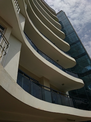 Een modern gebouw met gebogen balkons en een glazen gevel.