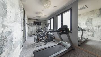 A gym with treadmills, elliptical machines, and a stationary bike.