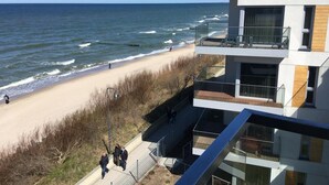 Un bâtiment moderne doté d’un balcon donnant sur une plage.